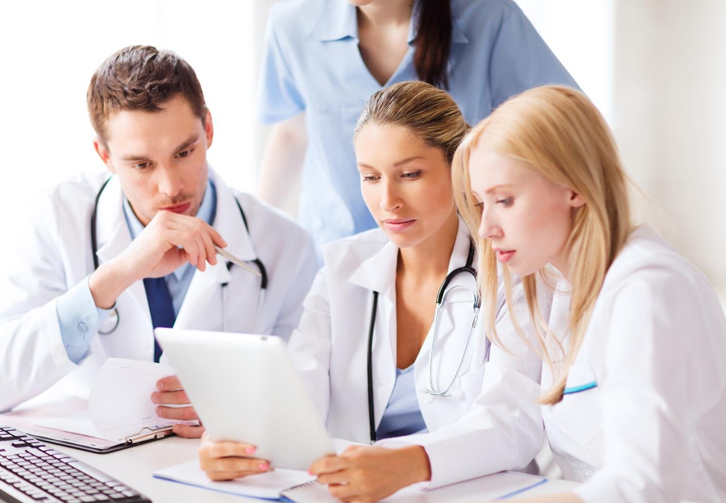 Group of doctors looking at a tablet 