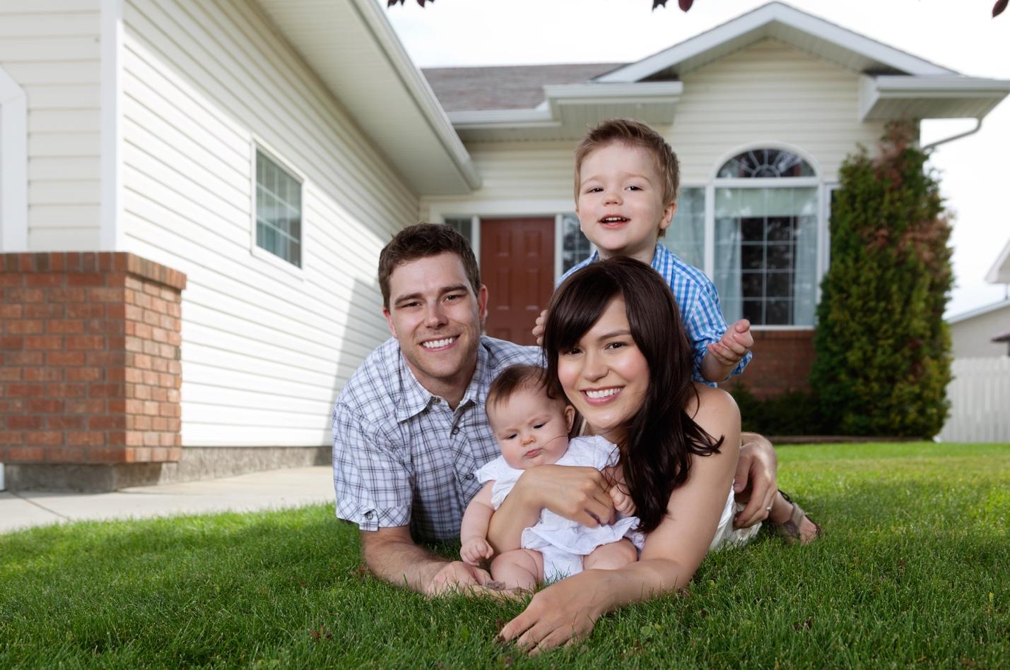 Family lying on grass outside the family home